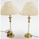 Two brass and glass table lamps, each on a twist glass column on a stepped brass base with cream sha