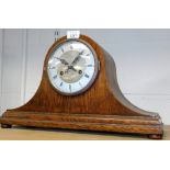 An oak cased Nelson's hat shaped mantel clock, with silver coloured dial on bun feet.