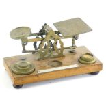 A set of early 20thC miniature brass table scales, with some weights, 23cm wide.