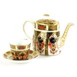 A Royal Crown Derby Imari pattern miniature trio, comprising teapot, 8cm high, cup and saucer. (3)