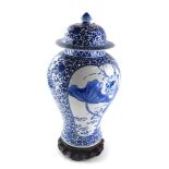 A late Chinese porcelain baluster vase and cover, decorated with lotus flowers, birds, etc., in blue