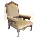 A Victorian gothic open armchair, with an arched back, carved with leaves, etc., on turned legs.