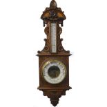 A late 19th/early 20thC carved oak barometer, with thermometer, stamped J Hall Bradford, 96cm long.