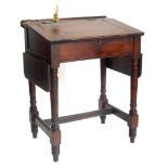 A Victorian pitch pine clerks desk, the sloped top with recess for inkwell and a adjustable candle s