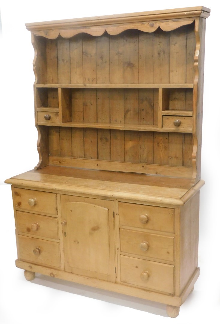 A pine dresser, the associated raised back with various shelves and two drawers, the base with a mou