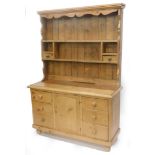 A pine dresser, the associated raised back with various shelves and two drawers, the base with a mou