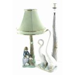 Two Nao porcelain table lamps, one depicting two geese, another a lady with rabbits.