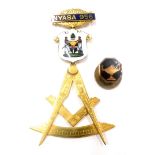 A Masonic jewel, the top bar marked NYASA 956, with enamel decorated shield of two figures, marked t