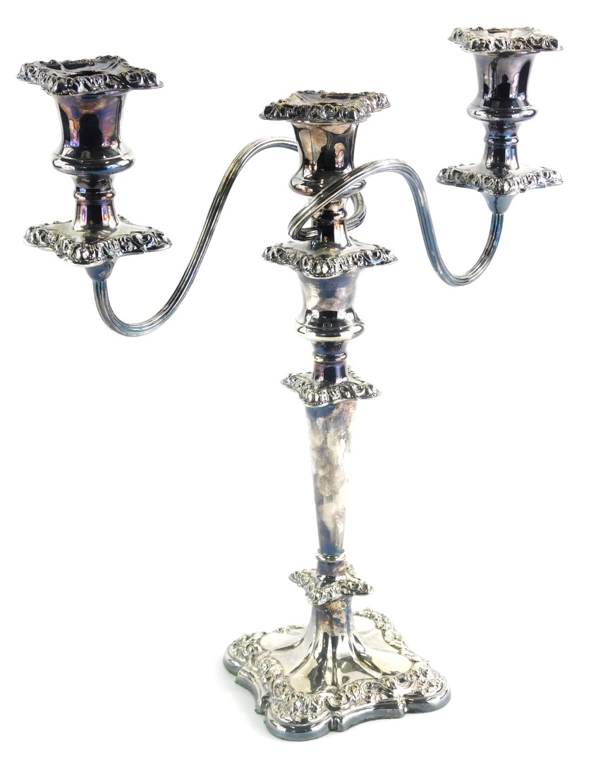 A 20thC silver plated three branch candelabrum, of shaped form with entwined upper stem on a taperin