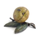 An early 20thC cold painted metal money box, modelled in the form of an apple with a beetle and leaf