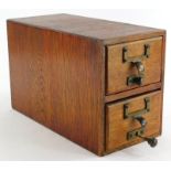 An early 20thC two drawer pine library card box, with contents, 21cm high, 8cm wide, 32cm deep.