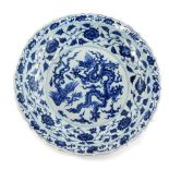 A Chinese blue and white charger, with a shaped edge decorated in blue with dragon, six character ma