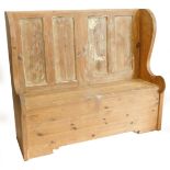 A pine settle, with a panel back, shaped sides, 138cm wide.