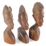 Three various African tribal carvings, head profiles with elaborate hair, 23cm high. (3)