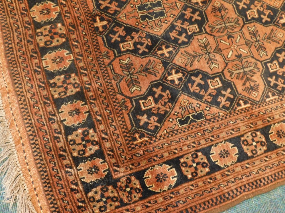 A Balouch type rug, with a design of medallions, in rust coloured medallions on a navy ground with m - Image 2 of 3