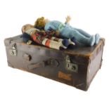 An early 20thC vintage pressed leather travel case, containing dolls, to include one in Highland dre