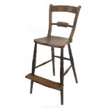 A 19thC Oxfordshire ash and elm bar back adult sized highchair, with turned legs and foot platform,