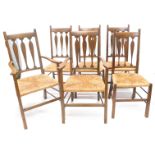 A set of six early 20thC Arts and Crafts style oak dining chairs, each with triple vase shaped splat