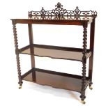 A Victorian rosewood three tier whatnot, with fret carved back, three shaped shelves, each on spiral