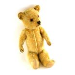 An early to mid 20thC teddy bear, with button shaped eyes, 39cm long.