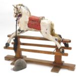 A Victorian dapple grey rocking horse, the pitch pine trestle stand with indistinct label, (AF), 120