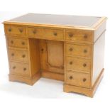 A 19thC birdseye maple pedestal desk, the top with a brown leather border, above an arrangement of n