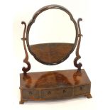 A burr walnut dressing table mirror, with a shaped plate on scroll supports, the bowfronted box base