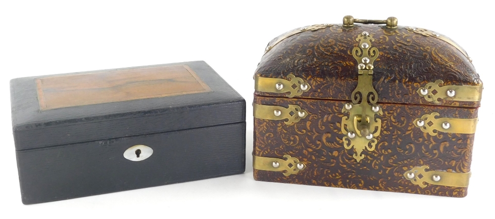 A pressed leather casket, of domed form with swing brass handle and brass mounts, with elaborate esc