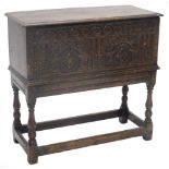 An oak chest, the rectangular top with a moulded edge above an elaborately carved frieze of arches,