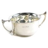A George V silver two handled cup, of plain form with angular scroll handles each cast with an acorn