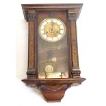 A late 19th/early 20thC Vienna type wall clock, in a walnut case with stencilled decoration, retaile