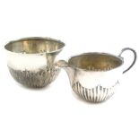A Victorian silver milk jug and sugar bowl, each with part fluted decoration, London 1895 and 1896,