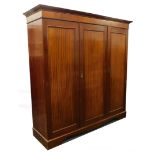 An Edwardian mahogany triple wardrobe, with a moulded cornice and a partly fitted interior, on brack