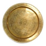 A large early 20thC Eastern brass tray or table top, of circular form with floral outline, heavily d