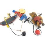 An Edwardian style child's iron weighted boy in boat toy, partially painted, 38cm high, another form