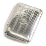 A George V silver match holder, of rectangular form with engine turned decoration and a monogrammed