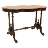 A Victorian figured walnut centre table, the shaped top with a central marquetry decoration of scrol
