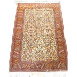 A Persian rug, with an all over design on a cream ground with one wide, two narrow borders, 143cm x