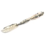 A Victorian silver butter knife, the blade decorated with leaves, scrolls, etc., and the handle cast