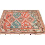 A Kilim rug, with a geometric design in green, blue, navy cream, etc., 199cm x 294cm.