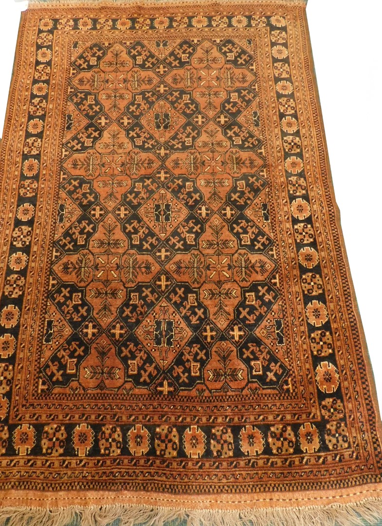 A Balouch type rug, with a design of medallions, in rust coloured medallions on a navy ground with m