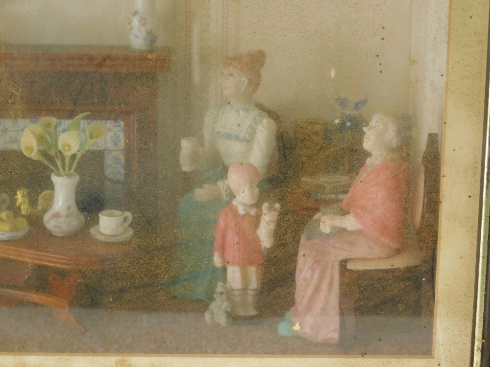 A cased electrical diorama, a family in a living room, with table and fire place, in glazed case wit - Image 2 of 3