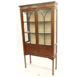 An Edwardian mahogany and boxwood strung display cabinet, with two glazed doors on square tapering l