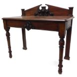 A Victorian mahogany hall or serving table, the raised back mounted centrally with a cartouche and