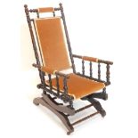 A 19thC turned walnut American type rocking chair, with padded back, armrest and seat.