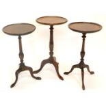 Three mahogany wine tables, each with a dished top, a turned column and a tripod base, 53cm, 57cm an