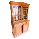 A pine and pitch pine cabinet, the top with a shaped cornice above two glazed doors inset with engra