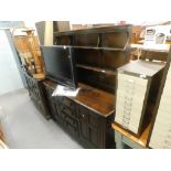 A dark Ercol Welsh dresser, the top with two shelf plate rack, the base with four short drawers flan