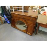 A mahogany sideboard, with a mirrored back and two drawers above two hinged doors.