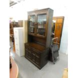 A dark Ercol display cabinet, the top with two glazed hinged doors, the base with two hinged doors,